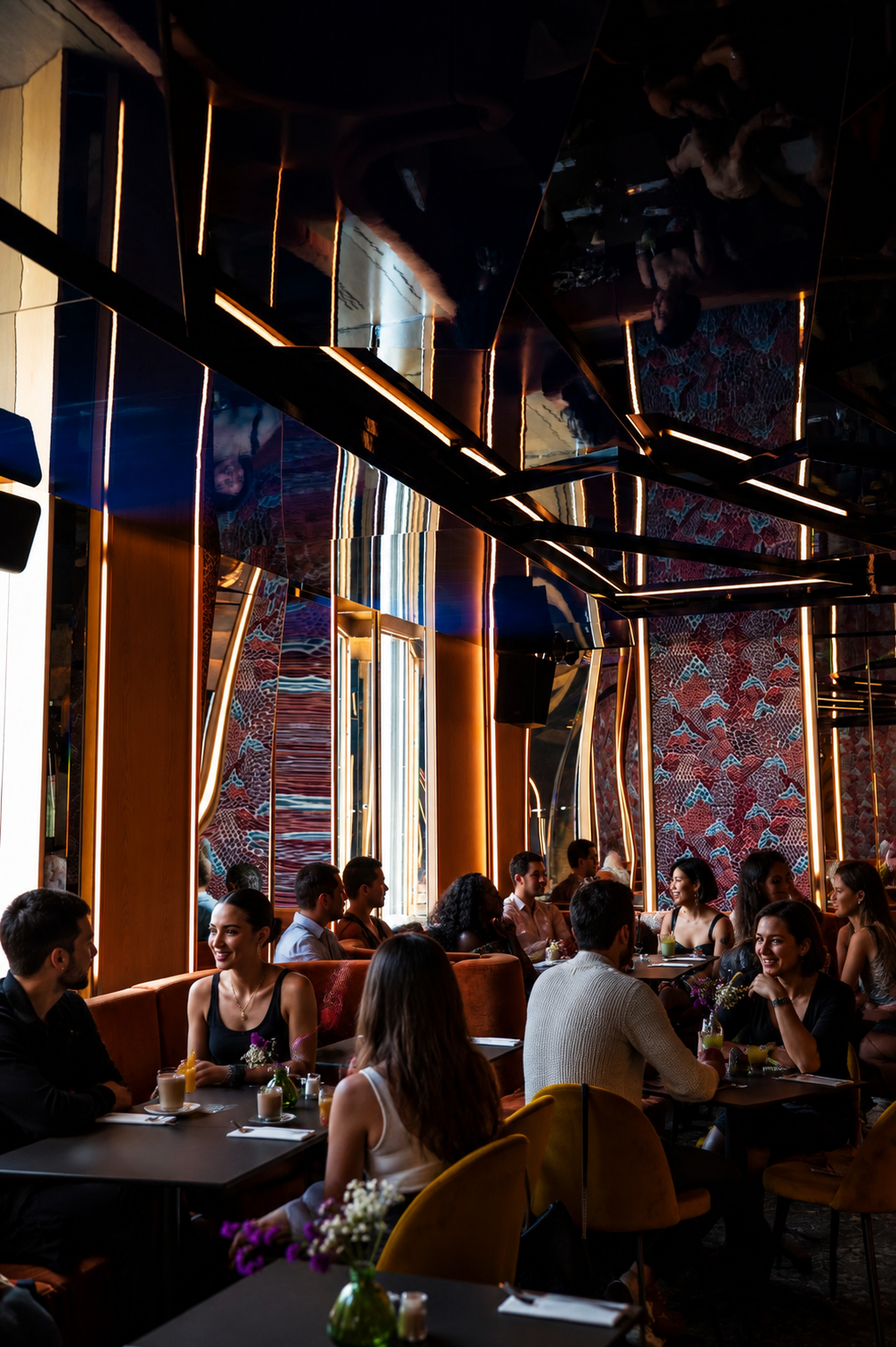 Salle du restaurant en plein service, lumière naturelle d'un samedi — tension joyeuse